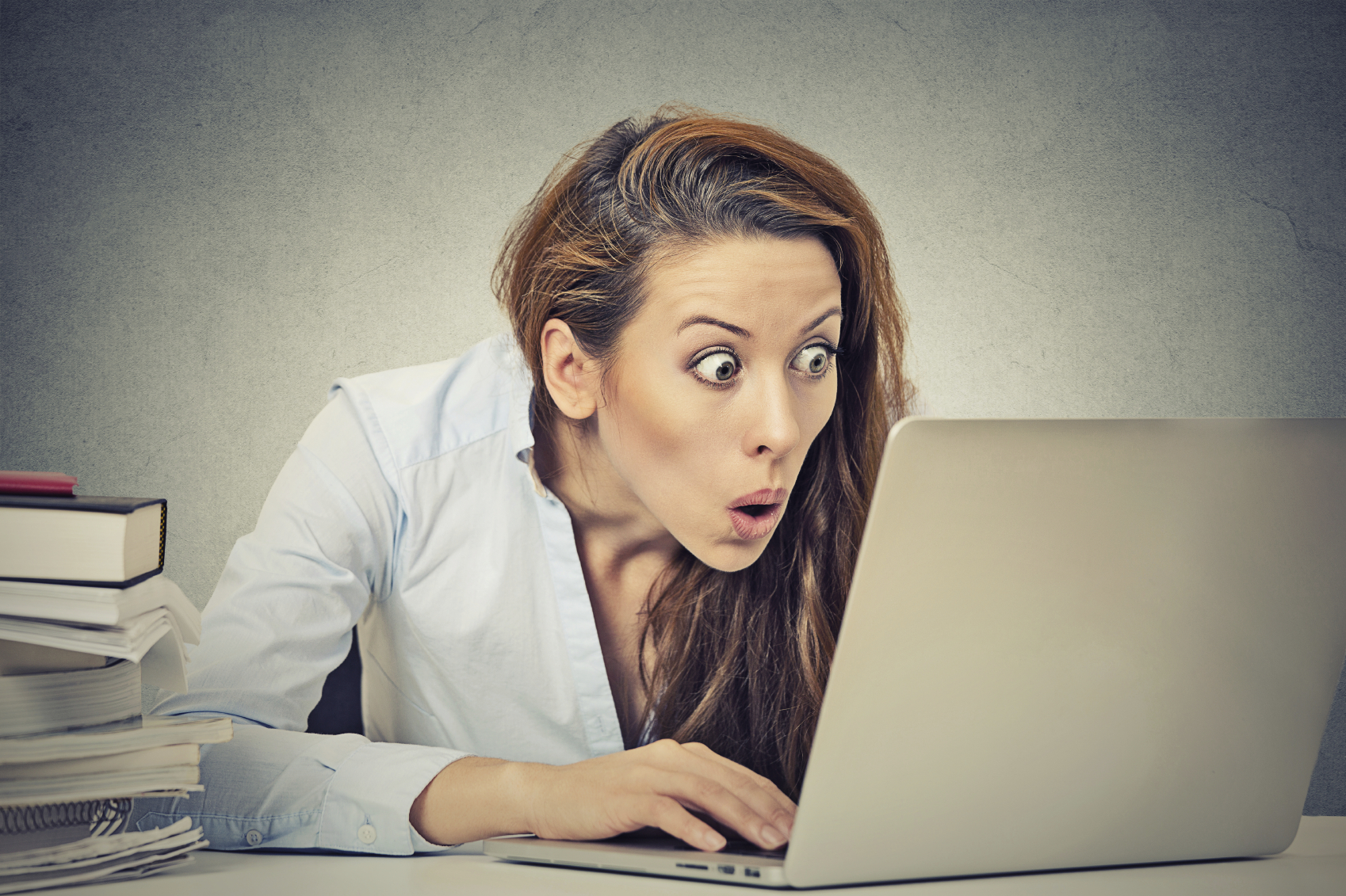 shocked business woman sitting in front of laptop computer
